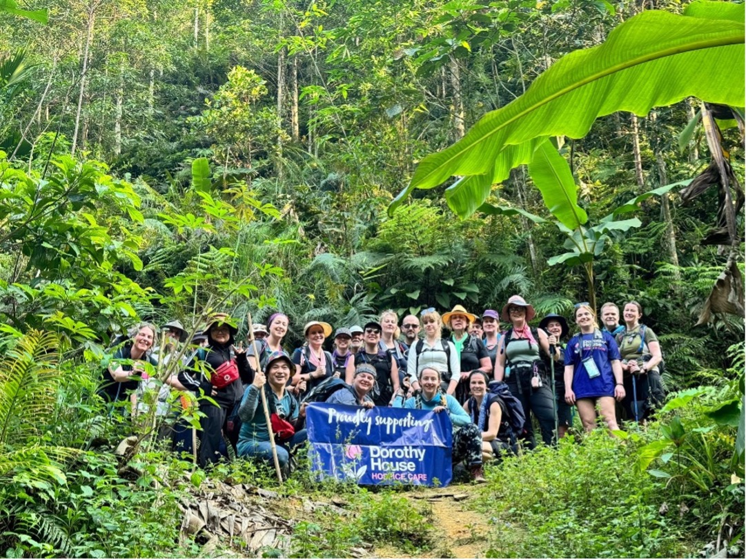 Hospice trekkers in the jungle holding a banner which reads "proudly supporting Dorothy House"