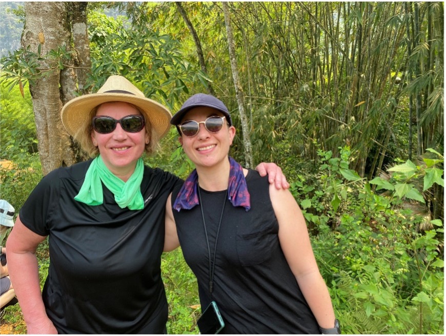 Two woman wearing hats smiling for a photograph in jungle in Vietnam 