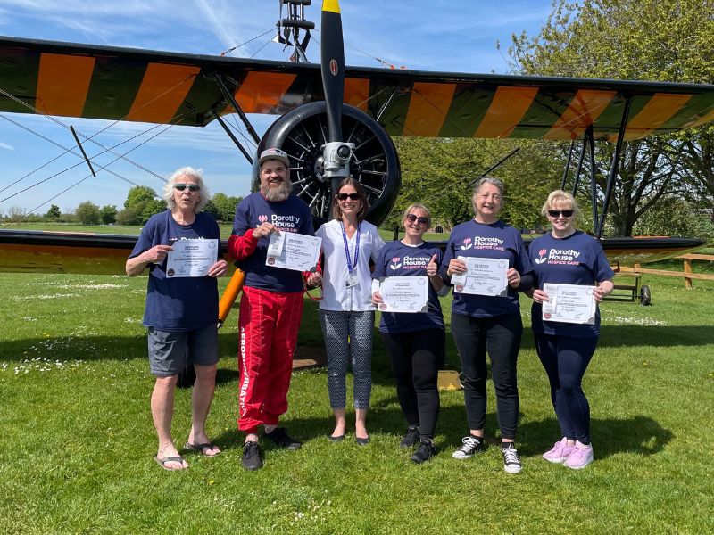 Dorothy House Wingwalkers with their certificates standing in front of bi-plane