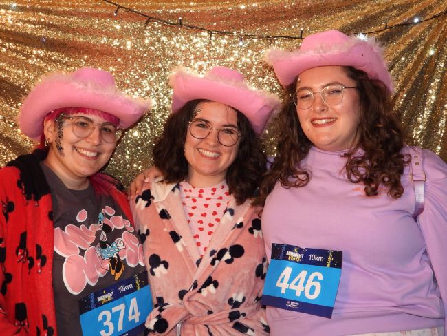 Anthea and her two friends wearing pink cowgirl hats at Dorothy House Midnight Walk 2024