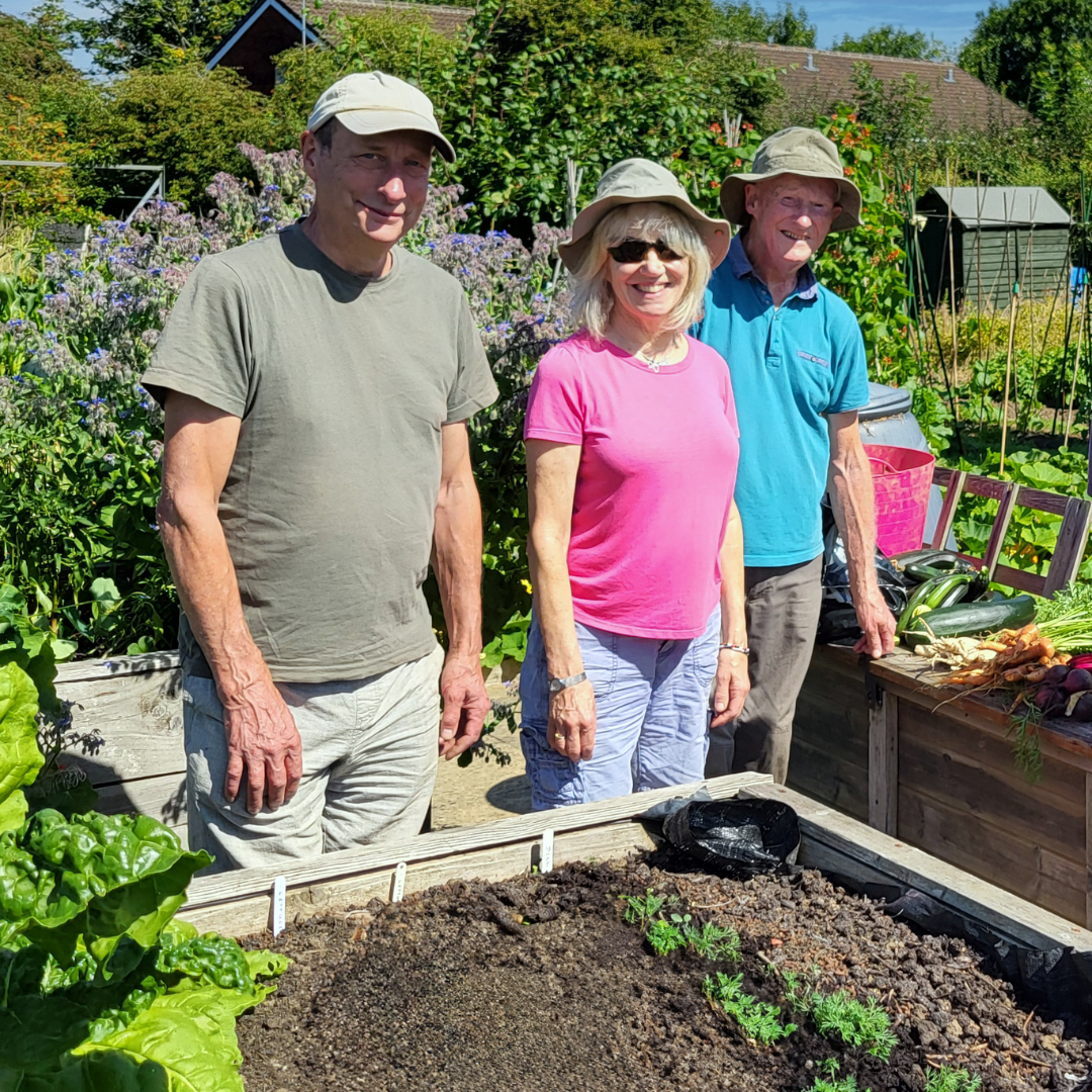 Three members of the Dorothy House Allotment Group stood by one of their garden plots.