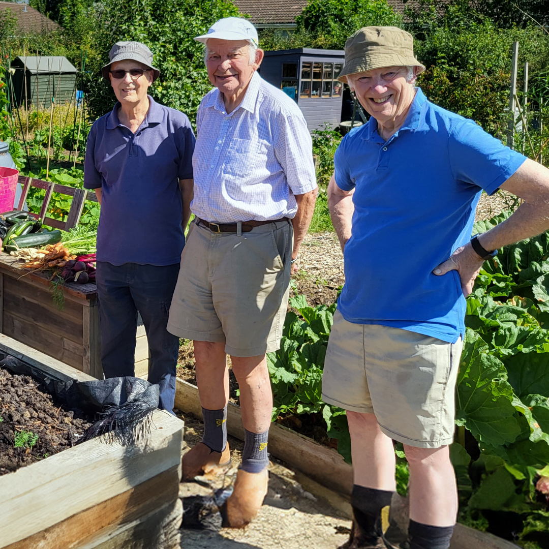 Three members of the Dorothy House Allotment Group stood by one of their garden plots.